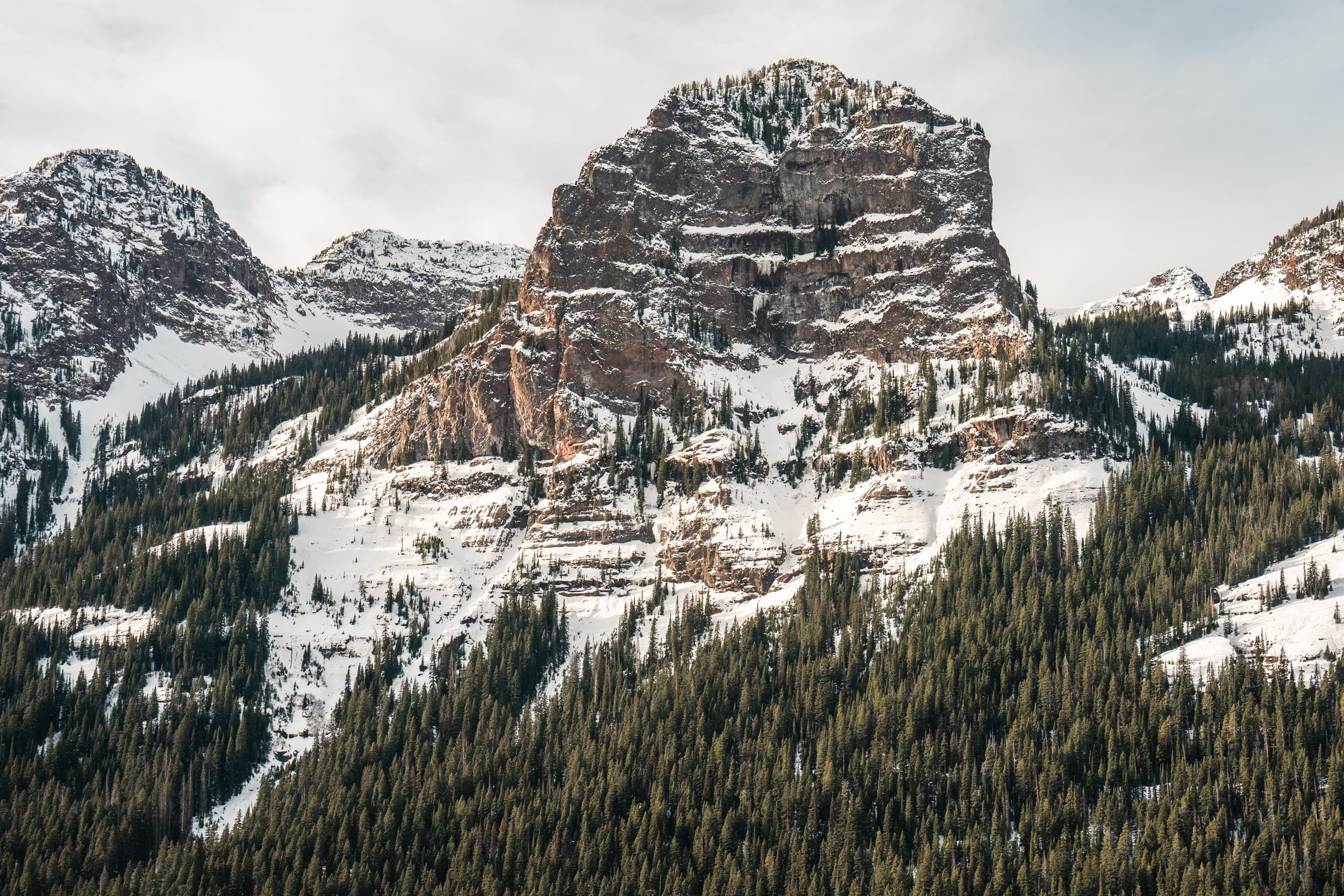 Hyalite butte dusted with snow above dark forest