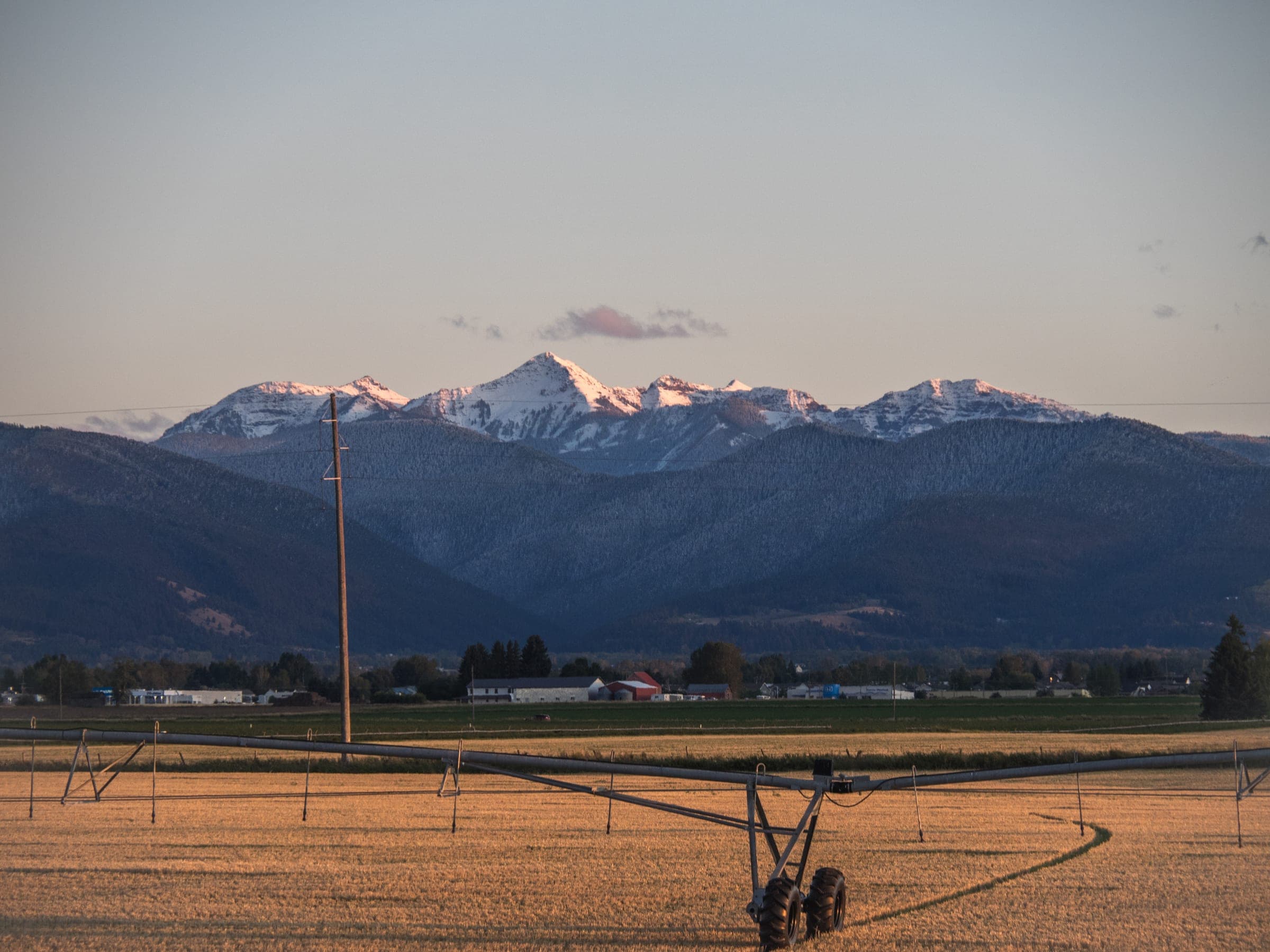 Spanish Peaks in alpenglow above a ranch and irrigation pivot