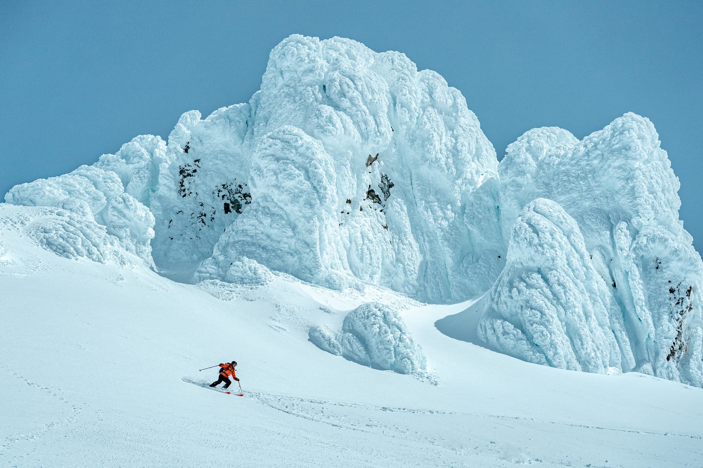 Skier dwarfed by surreal rime-ice towers