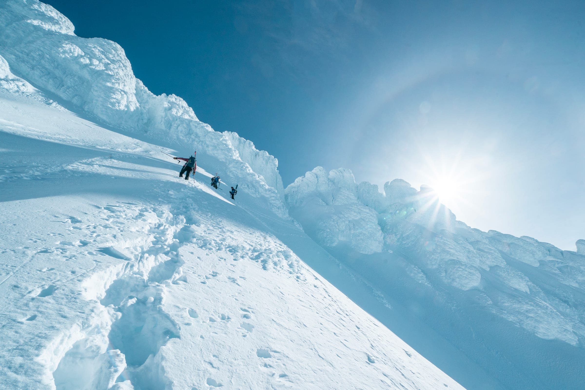 Sun halo over rime towers with a line of tiny climbers