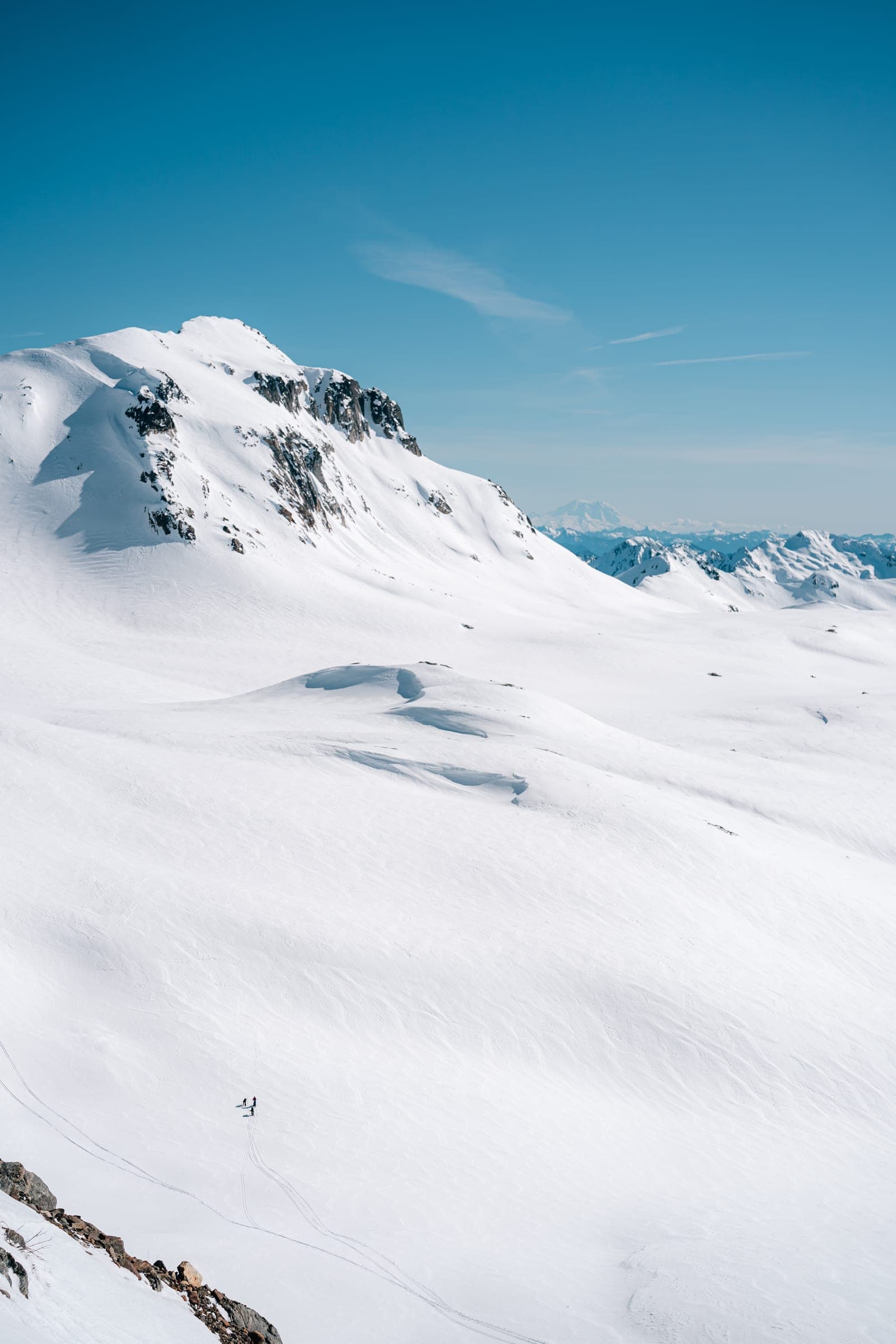 Glacier Peak: tiny skier in a vast snow bowl below the summit