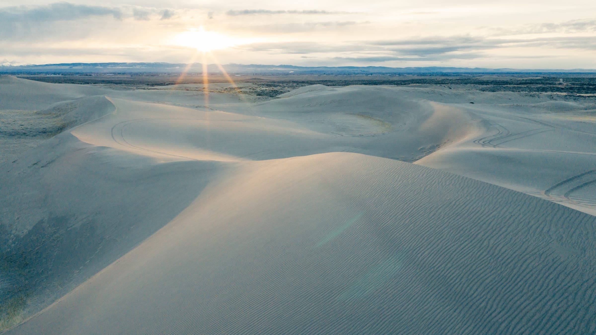 Sunstar over endless sand dunes from above