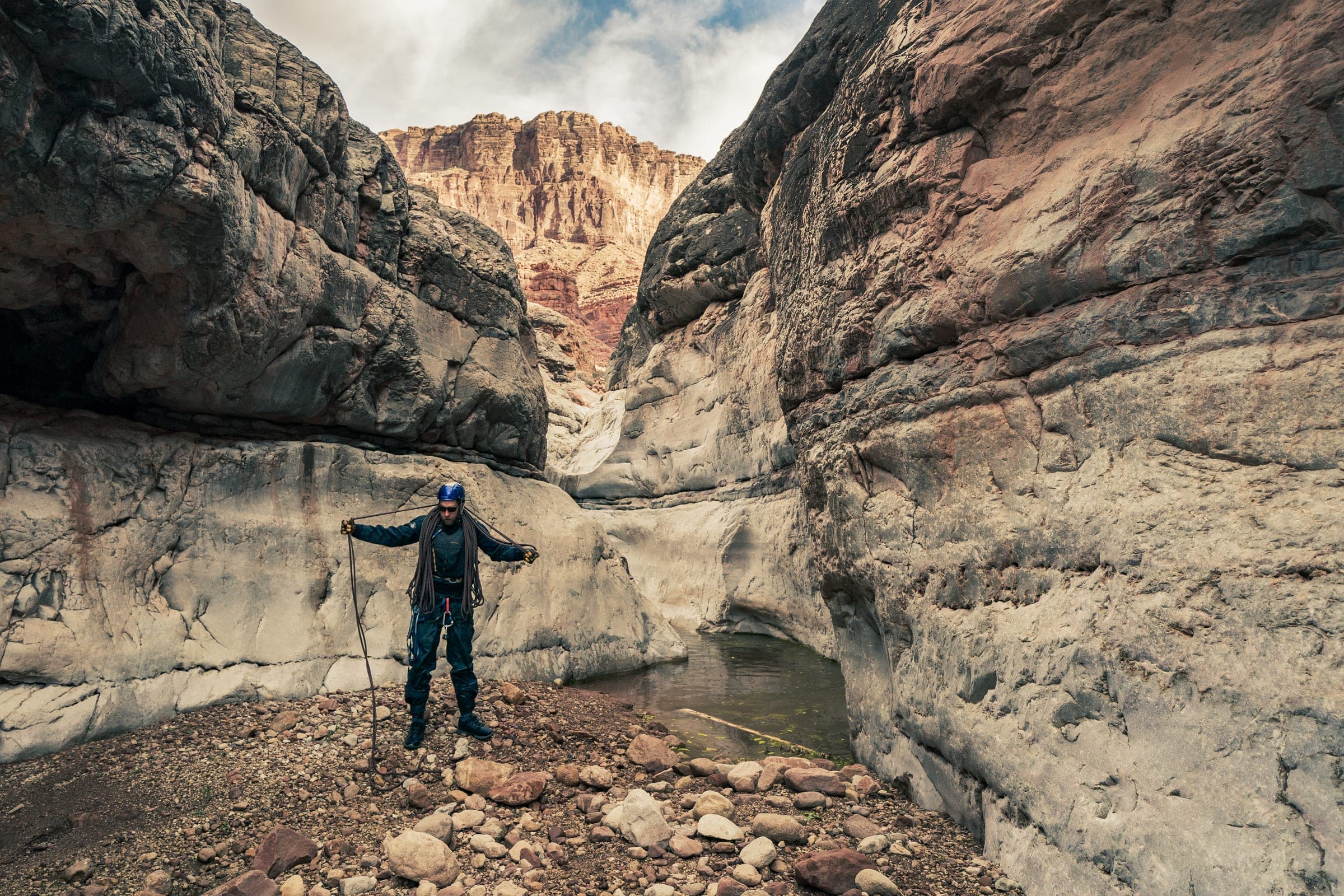 Figure with arms out in a towering sandstone canyon