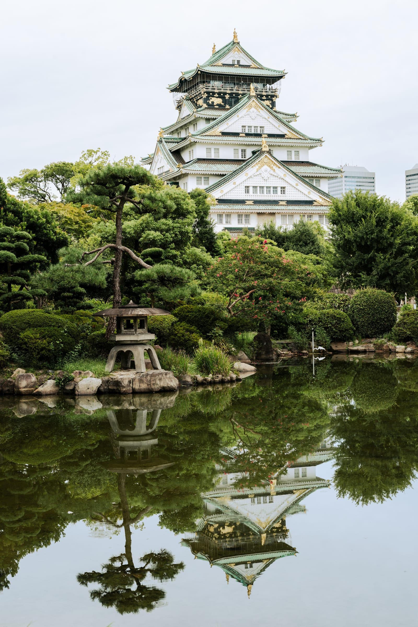 Osaka Castle reflected in a still garden pond