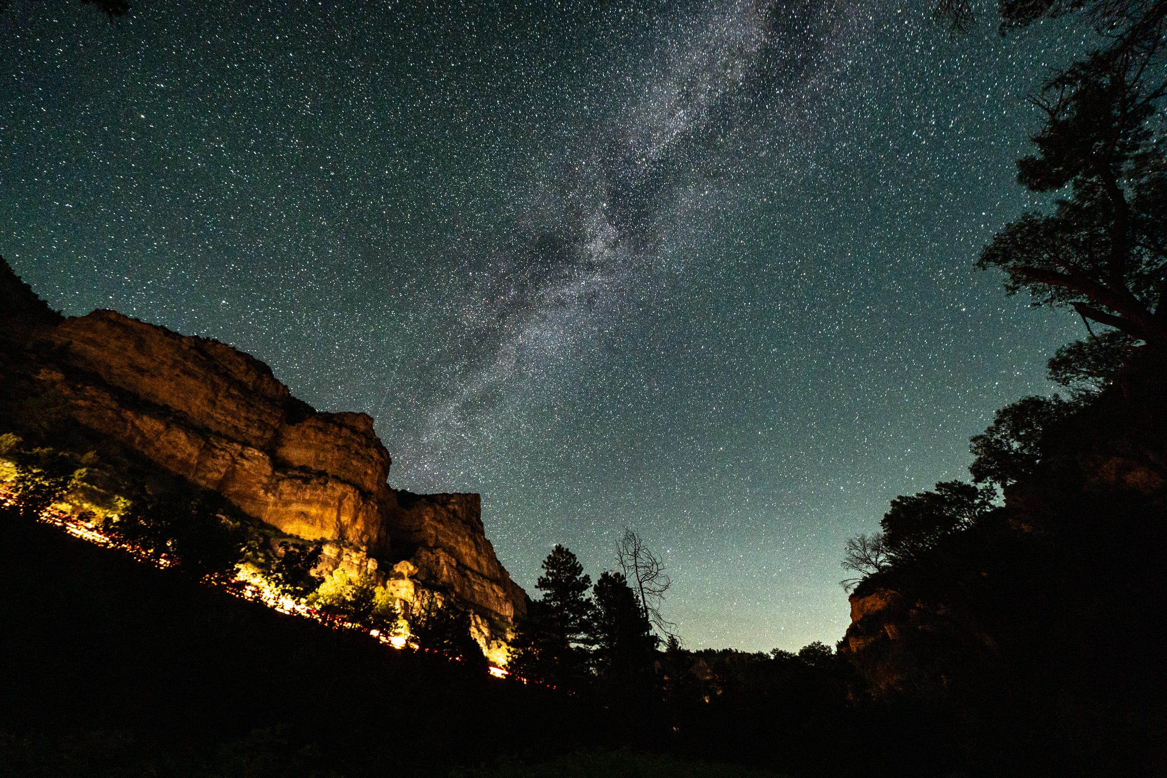 Milky Way over a lamp-lit canyon wall, Ten Sleep