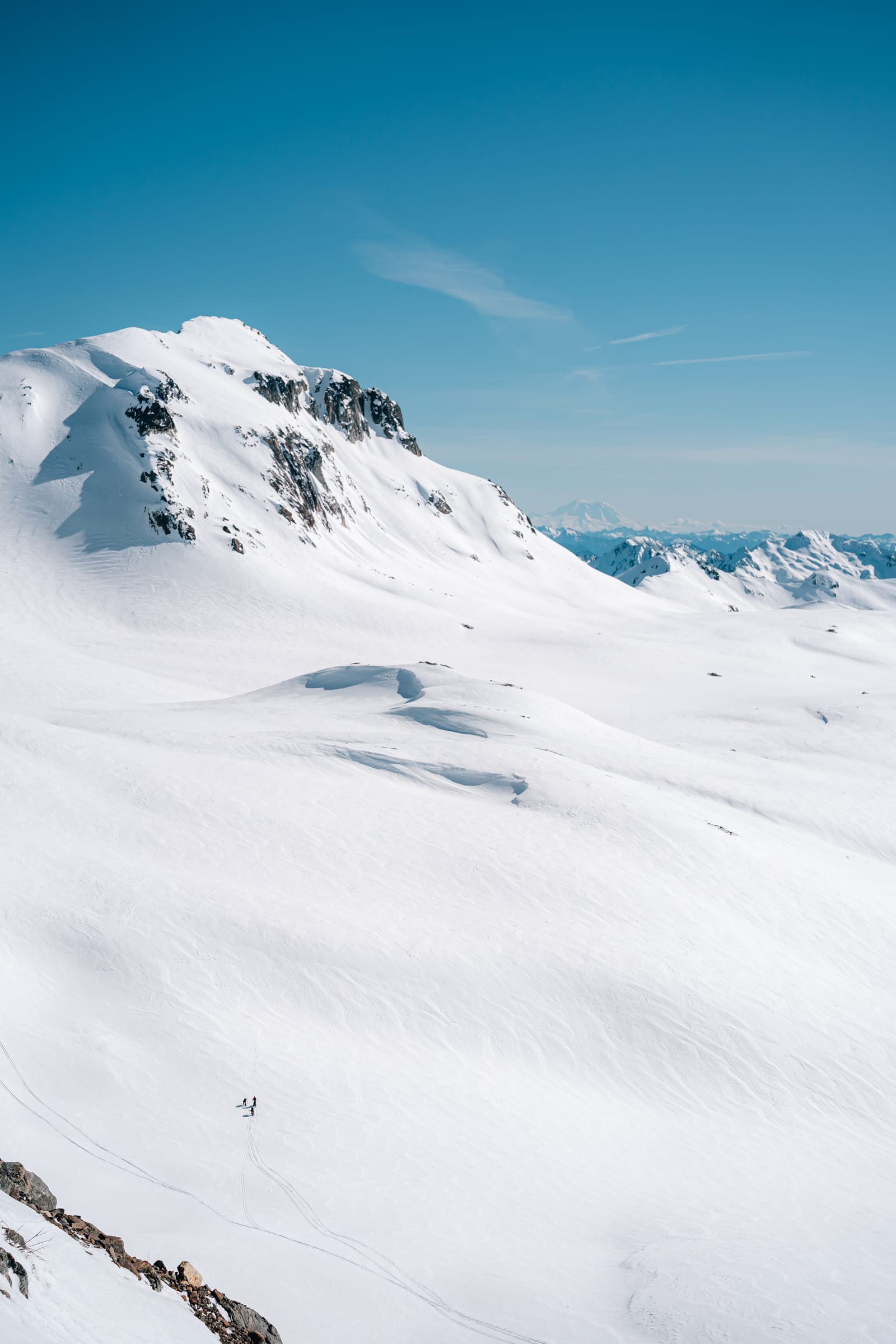Glacier Peak: tiny skier in a vast snow bowl below the summit