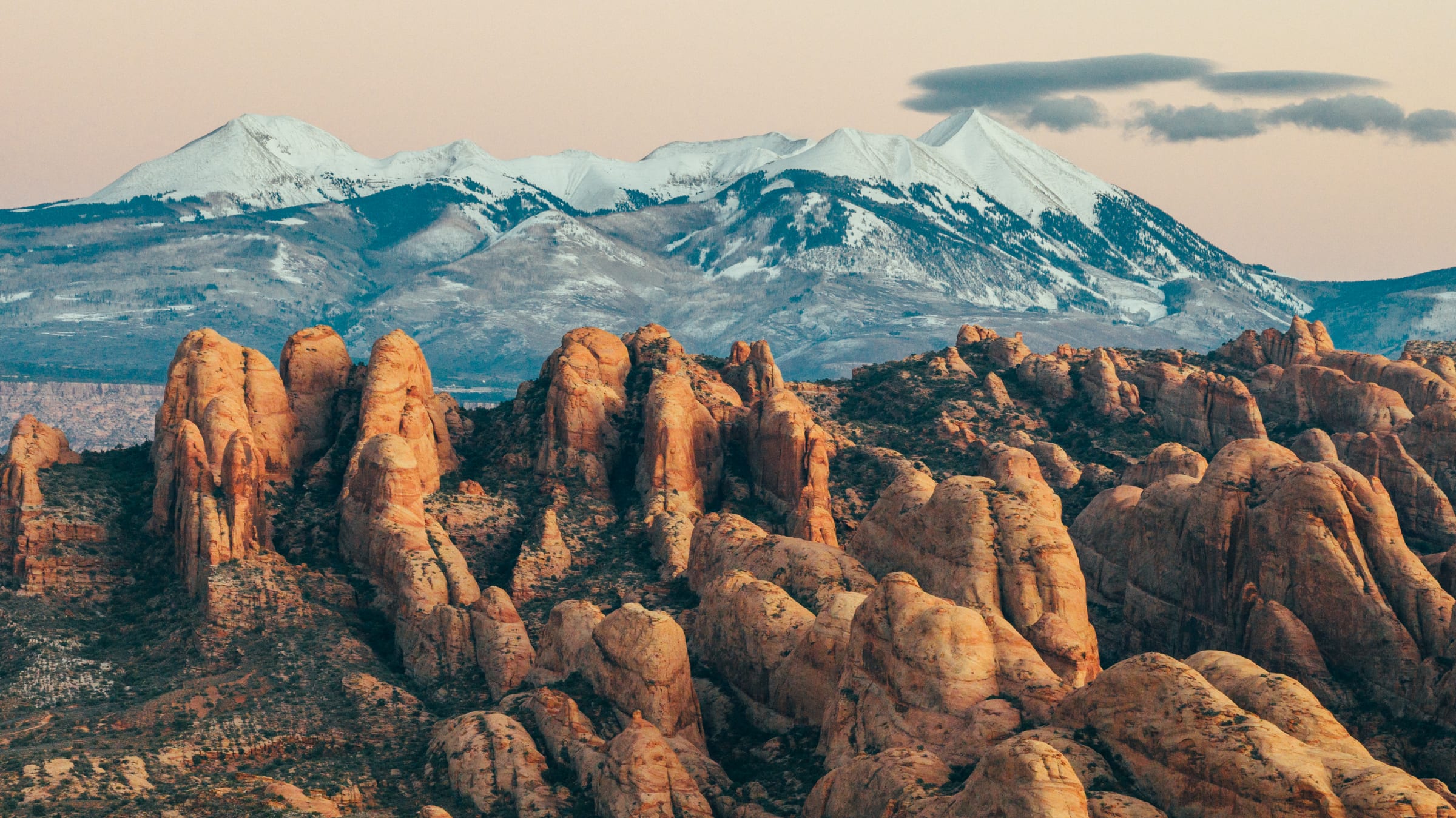 Drone view of glowing fins below snowcapped La Sals