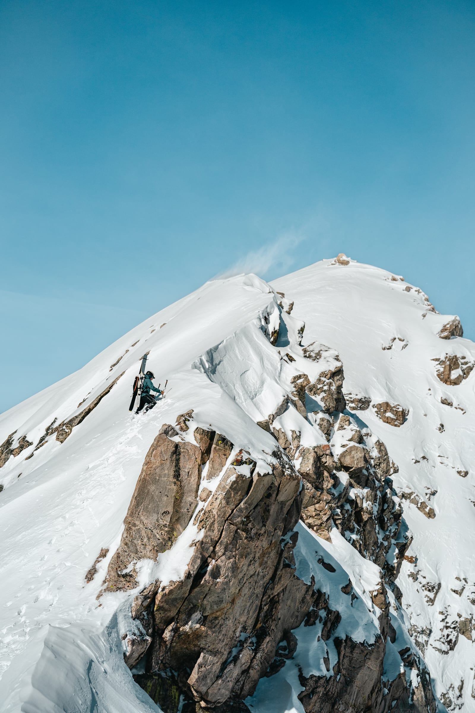 Tiny climbers on the knife-edge summit ridge above the valley