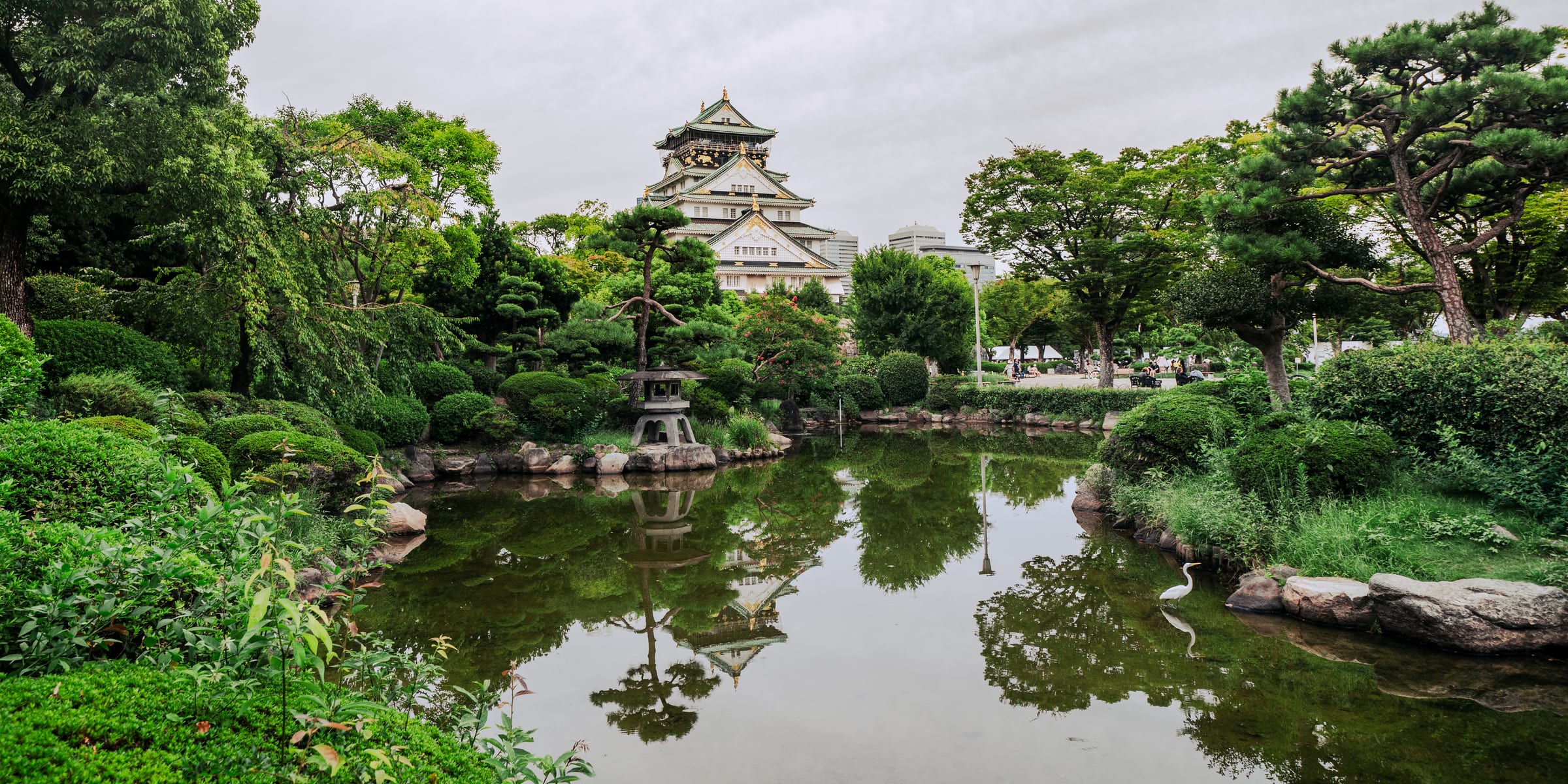 Wide landscape of Osaka Castle over its garden pond